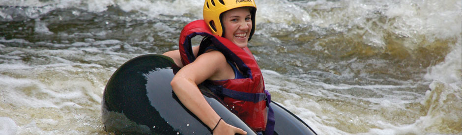 Smiling women in an inner tube floating down the gorge