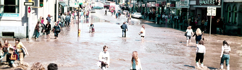 Flood of 1974, downtown Galt (cambridge) with crowd of people in street