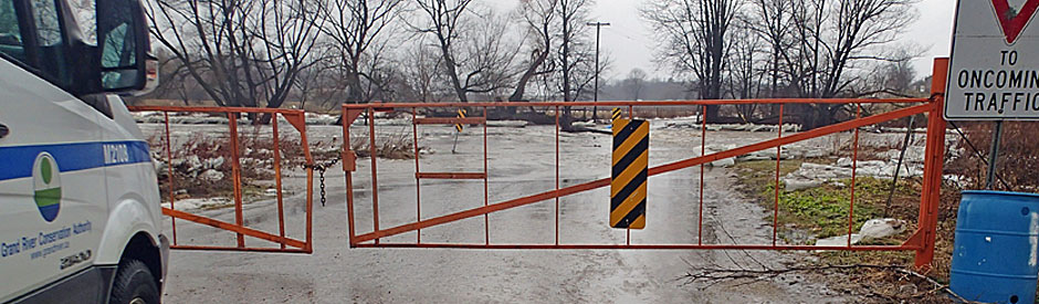 Flooded road with emergency gates across it, closing it