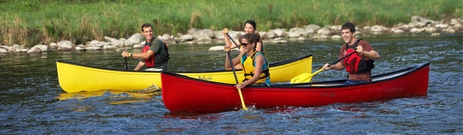 Smiling young people paddling the Grand River
