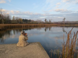 Man sitting at water's edge at Laurel Creek reservoir