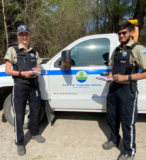 Two security guards standing beside GRCA truck